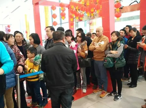 排隊(duì)領(lǐng)年貨，一家老小齊上陣。
