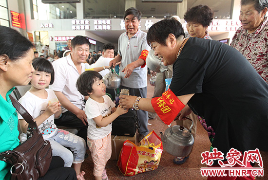 老年雷鋒團(tuán)”志愿者在候車廳為旅客送水。