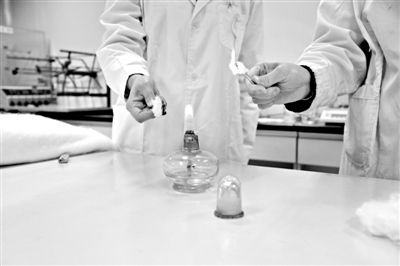 實驗人員操作的燃燒檢測法中，真蠶絲離開火焰就熄滅(左)。