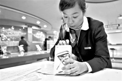 11月6日，北京移動西直門營業(yè)廳的工作人員在為顧客購買的4G手機登記。新華社發(fā)