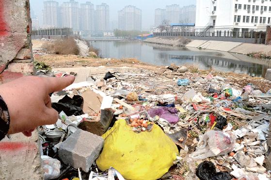 金水河長江路橋下河水發(fā)臭，水邊堆放眾多垃圾