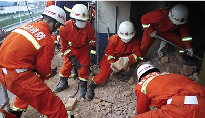 消防人員在清理熔鹽爐倒塌的廢墟。