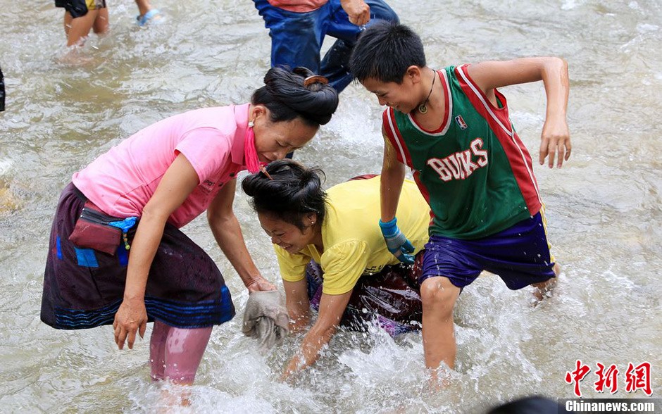 7月9日，村民在小河里摸魚(yú)搶魚(yú)。譚凱興 攝