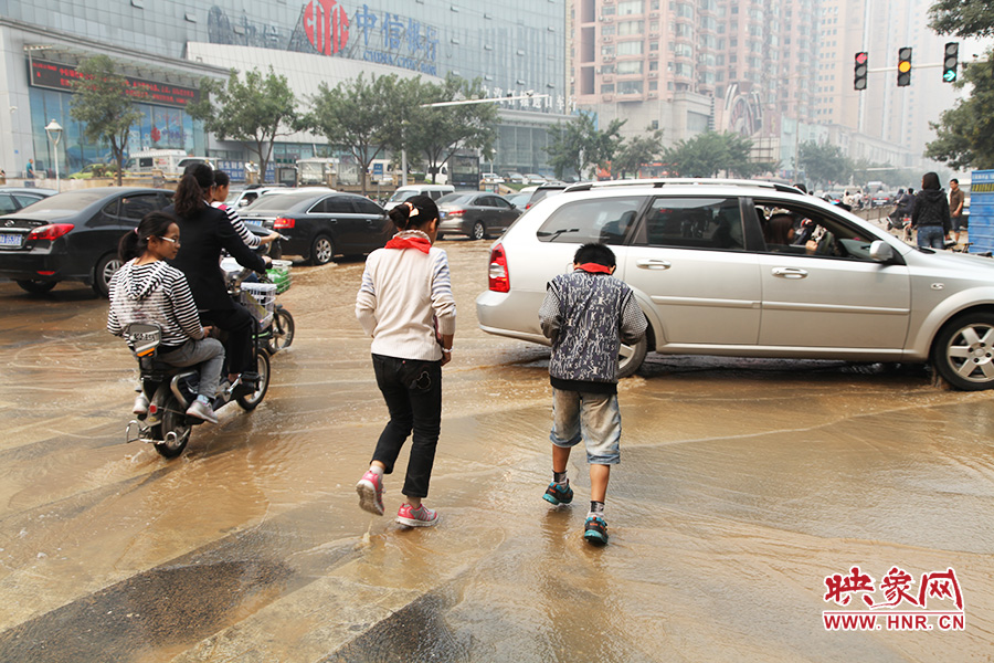 放學路過的學生在路口玩水嬉戲 放學路過的學生在路口玩水嬉戲