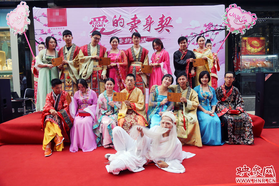 現(xiàn)場8對兒年輕男女舉起“賣身契”集體拍照。