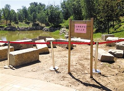 圓明園規(guī)月橋橋體構(gòu)件區(qū)域的警戒線和提示牌。 新京報記者 鄧琦 攝