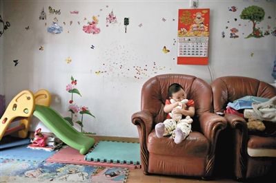 6月14日，未婚媽媽于軍的家里。女兒悅悅抱著兔子玩偶，在聽(tīng)媽媽手機(jī)上的兒歌，這個(gè)4歲女孩喜歡兔子。