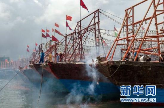 2013年8月1日 南海開漁日 臨高迎新港 8月1日，海南省臨高縣漁民在船上鳴放鞭炮慶祝武蓮港開港。