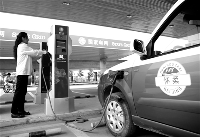 9月11日，懷柔區(qū)，電動(dòng)出租車司機(jī)正在為車輛充電。