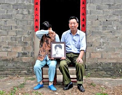 江蘇鎮(zhèn)江，老劉夫婦捧著獨(dú)生子的遺像在老家前留影南方都市報(bào)供圖L