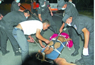 眾人合力將狂犬病發(fā)作的江某控制住。 孫東城 攝