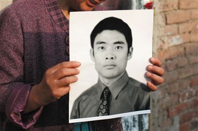 5月19日，朝陽(yáng)北路，母親捧著張東文的遺像。新京報(bào)記者 侯少卿 攝