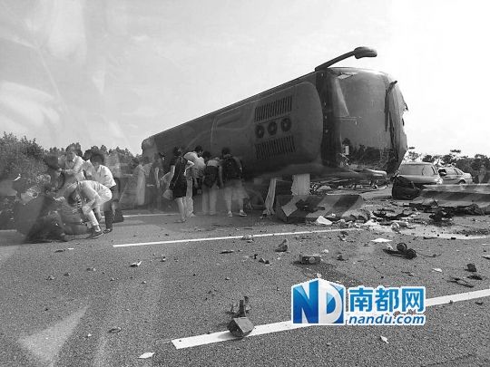 現(xiàn)場大客車側(cè)翻，玻璃碎落一地，車身卡在路邊水泥護欄上。 目擊者供圖