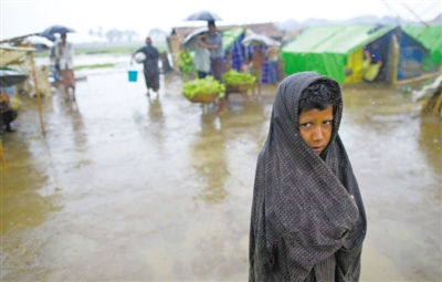 5月14日，緬甸若開邦實(shí)兌難民營，羅興亞族難民在雨中行走。熱帶風(fēng)暴“馬哈森”即將登陸緬甸，這里的難民開始乘船撤離。