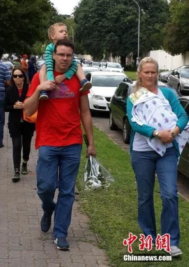 圖為一個(gè)白人家庭，由父母帶著孩子到曼德拉家門外悼念。中新社發(fā) 宋方燦 攝