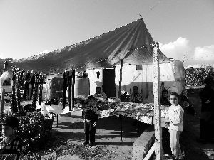 黎巴嫩一敘利亞難民營，難民支起攤鋪賣衣服掙錢。