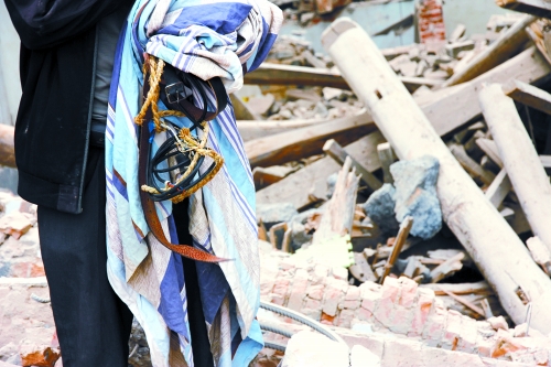 老人手中拿著曾控制住他的電線、床單