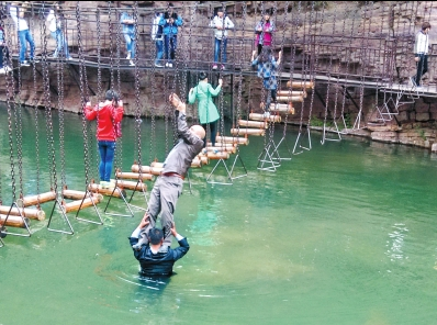 中年男游客正踩著景區(qū)安全員郭小明的肩膀過河。網(wǎng)友“@我的小名叫張孩”供圖