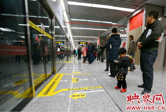 小朋友在等候區(qū)內(nèi)等待地鐵。