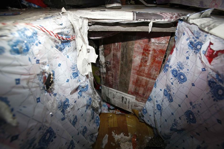 陳小龍?jiān)诔鲎馕萃猓孕杏謬鹨欢聡鷫?，安裝了一個(gè)門。圍墻上都是豎起的鐵釘，外面堆著土，鄰居猜是從地底挖出來的。洞口就在床邊，0.5米見方，深約1.5米。洞口表面一塊紙板掩蓋，打開紙板跳入洞底，是一扇小木門，木門外有插銷，可以從外面鎖上。