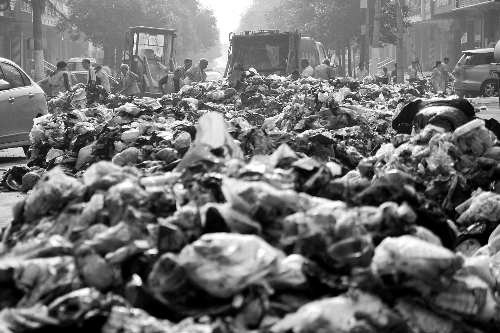 垃圾堆滿整個路口，環(huán)衛(wèi)工人們正在清理