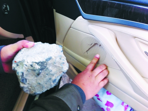 “飛”進寶馬車內(nèi)的大石塊,將寶馬車的車門內(nèi)飾板砸爛。