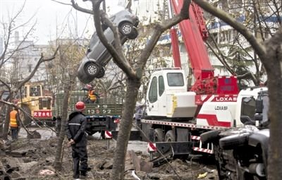 輸油管道爆炸后，搶修人員將被炸毀的車輛運(yùn)出現(xiàn)場(chǎng)。