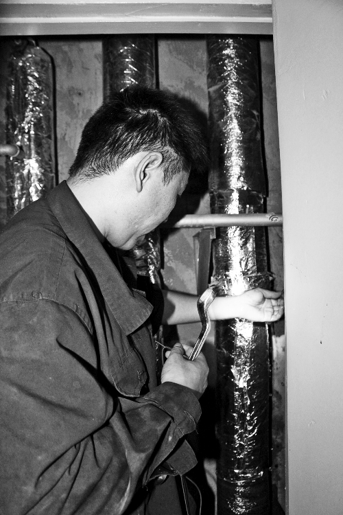 苗師傅一邊進(jìn)行維修，一邊用耳機(jī)接聽市民的電話。