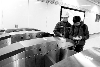 昨天上午，體育中心站，工作人員正在對進出站閘機進行調(diào)試。