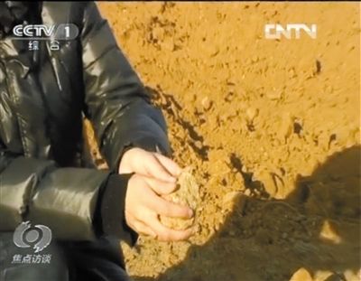 麻剛沙系麻剛石粉碎而成。記者找到一塊麻剛石，一捏就碎成粉末，硬度非常差。央視截圖