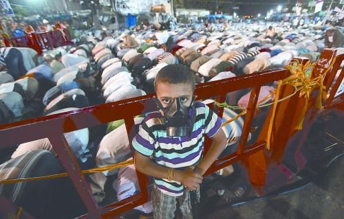 當(dāng)?shù)貢r(shí)間28日晚，在埃及開羅納賽爾城，一名小男孩頭戴防毒面具參加穆兄會(huì)的集會(huì)示威。