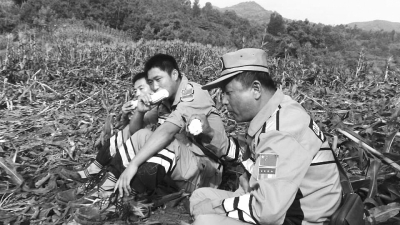 饑餓難忍，中國(guó)緊急救援河南基地的救援隊(duì)員在已毀的玉米地里撿拾生玉米吃。