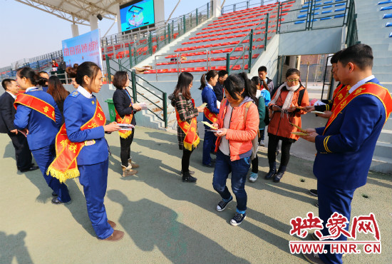 活動(dòng)現(xiàn)場(chǎng)工作人員給同學(xué)們發(fā)放宣傳冊(cè)、環(huán)保袋。