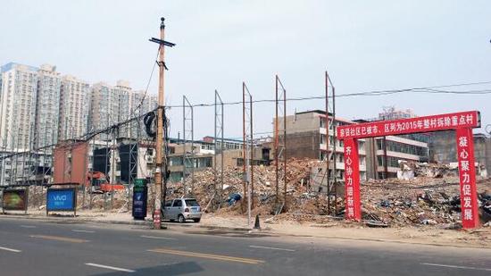 015年5月31日，在社區(qū)干部的帶頭拆遷下，親賢社區(qū)的“城中村改造”拉開帷幕。由于前期“清產(chǎn)核資”及補(bǔ)償標(biāo)準(zhǔn)等因素，拆遷改造工作推進(jìn)并不順利。圖為位于體育西路東側(cè)集體所有的商鋪率先被拆遷完畢，用于遮擋的圍擋正在施工中。（拍攝：2015年9月16日）