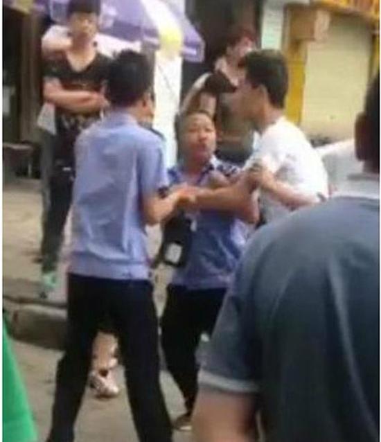 付某（右）與城管執(zhí)法人員廝打在一起。