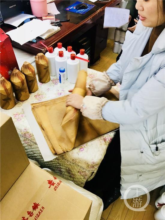 正在對(duì)白酒進(jìn)行包裝處理的經(jīng)營(yíng)戶。