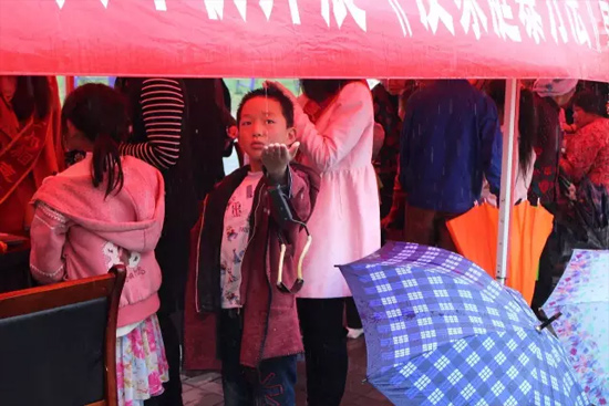 因為雨下的太大，小男孩玩起了接水游戲。