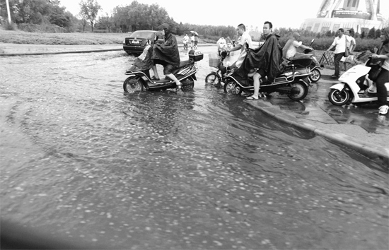 8月7日，鄭州一場暴雨，鄭州多處干道被淹，市民行路如過河