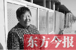 在京水村的臨時過渡區(qū)內，一位大媽在儲存大白菜