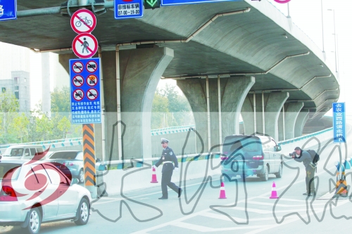 交警在東風(fēng)路從北向南上橋口處擺上反光錐，間歇放行