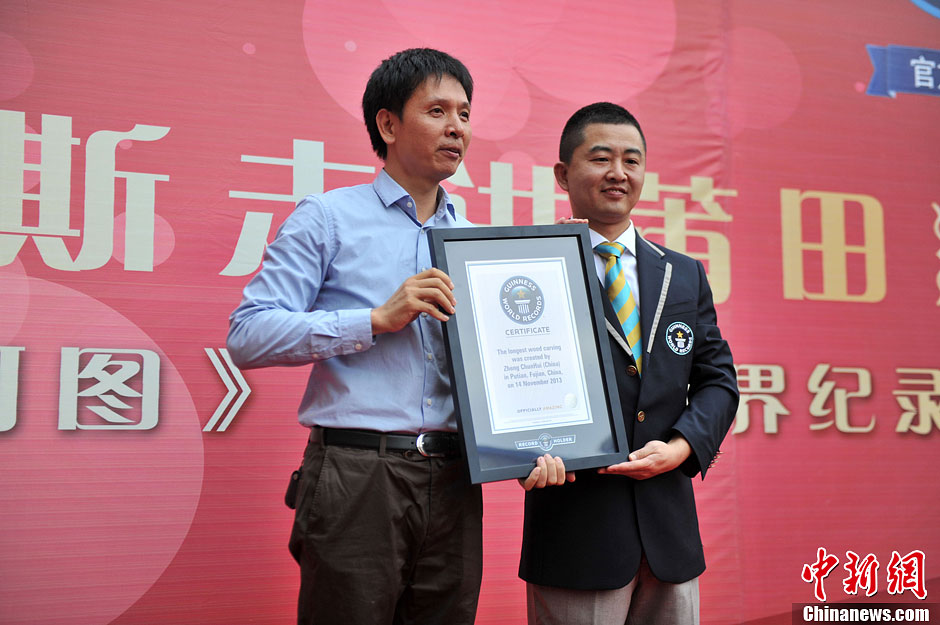 圖為世界吉尼斯認證官為鄭春輝（左）頒發(fā)證書。呂明 攝