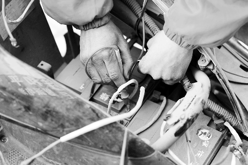 修車師傅正給電池做檢測(cè) 記者 張郁/攝 修車師傅正給電池做檢測(cè) 記者 張郁/攝