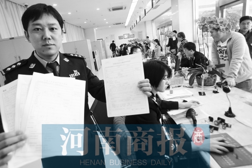 　民警左手拿的是新申請表，右手拿的是三份老申請表 王春勝/攝