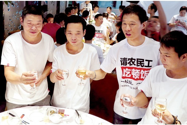 活動發(fā)起人張楠（右二）給農(nóng)民工敬酒。