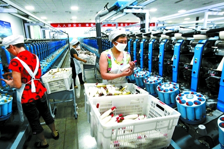 6月6日，舞鋼市鑫海紡織有限公司員工正在新建成的紡紗車間生產(chǎn)。