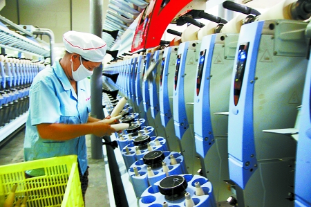 7月3日，在鄧州市永泰棉紡有限公司電腦控制全自動紡紗車間，紡織工人正在生產(chǎn)棉紗。