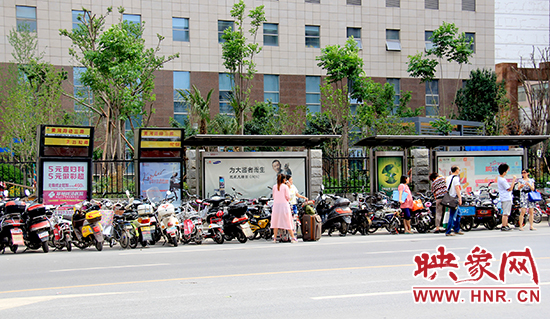 在黃河路經(jīng)三路公交站牌候車的乘客被“擠”到了路上 在黃河路經(jīng)三路公交站牌候車的乘客被“擠”到了路上