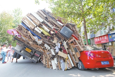 紅色小轎車被砸，卡在路邊動彈不得。