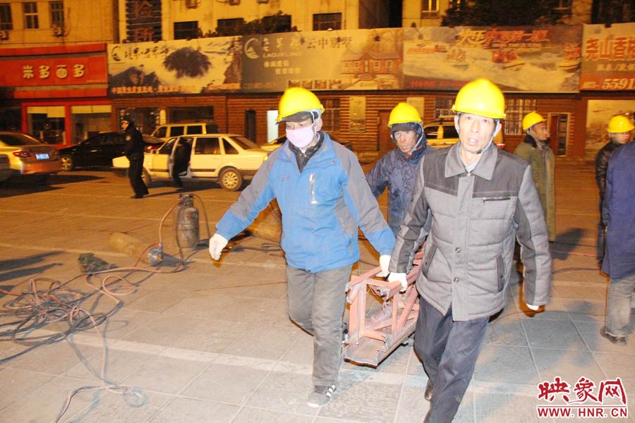 23點(diǎn)56分，第一塊兒廣告牌已經(jīng)分割完畢，地面上的20多名工人將拆除下來的鋼件撞車運(yùn)走。