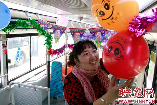 鄭州快速公交B3區(qū)間線車長李鵬云在車廂里懸掛氣球，布置圣誕車廂，營造歡樂圣誕氛圍